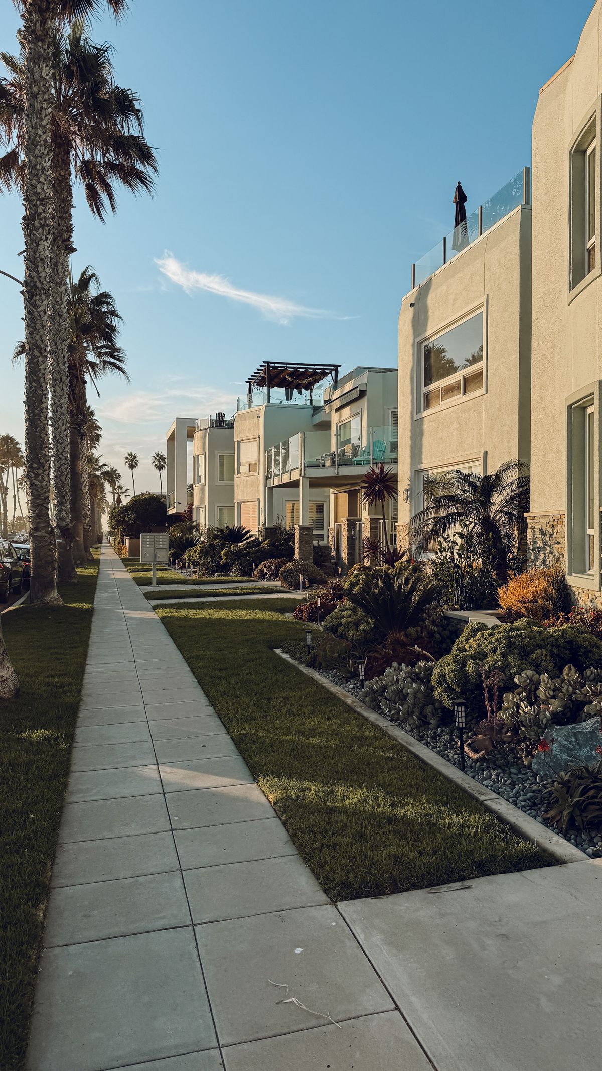 Sunny California beachside apartments with palm trees and clear blue skies.